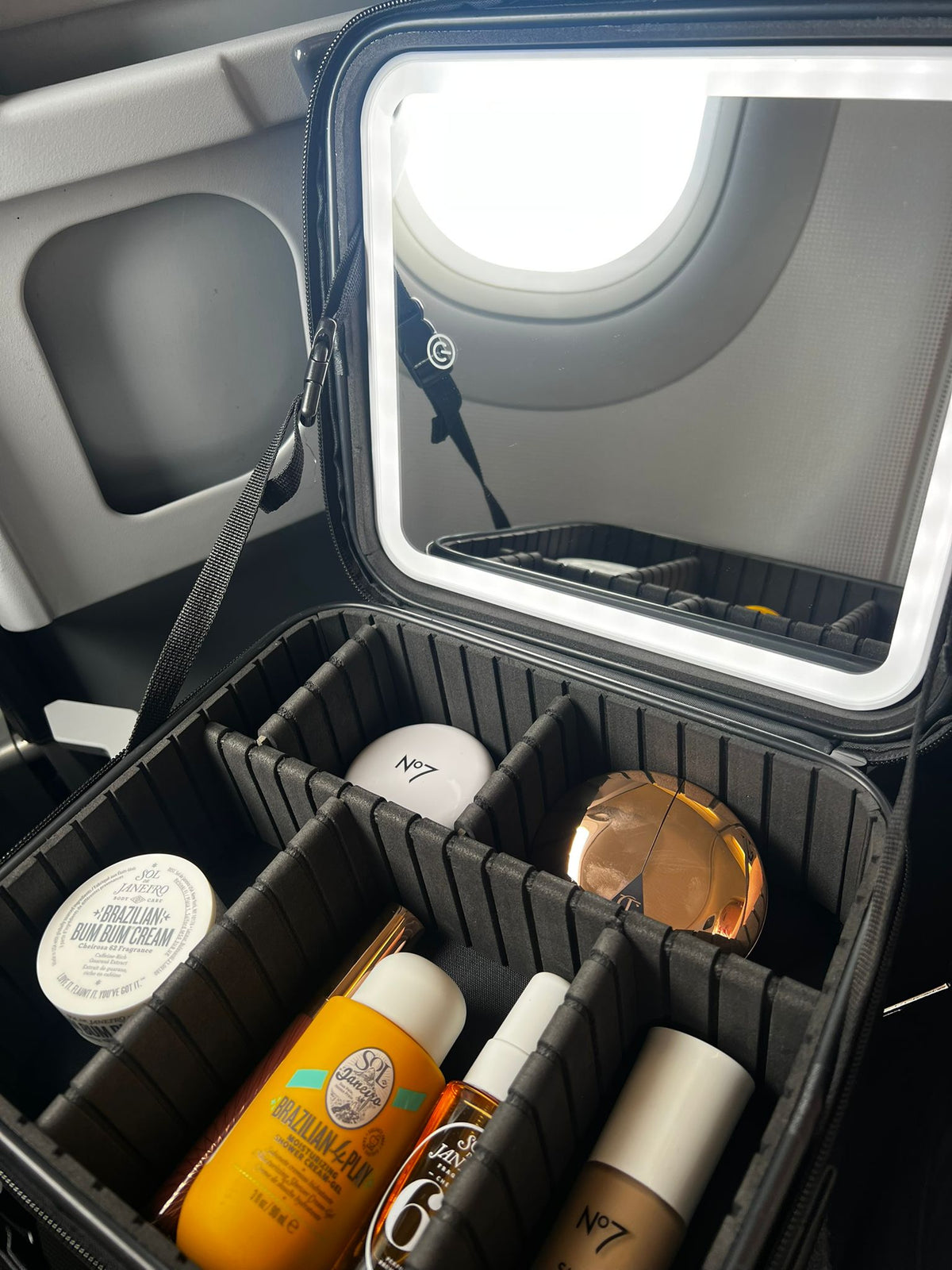 An open luxury LED makeup case with organized beauty products and a built-in mirror.